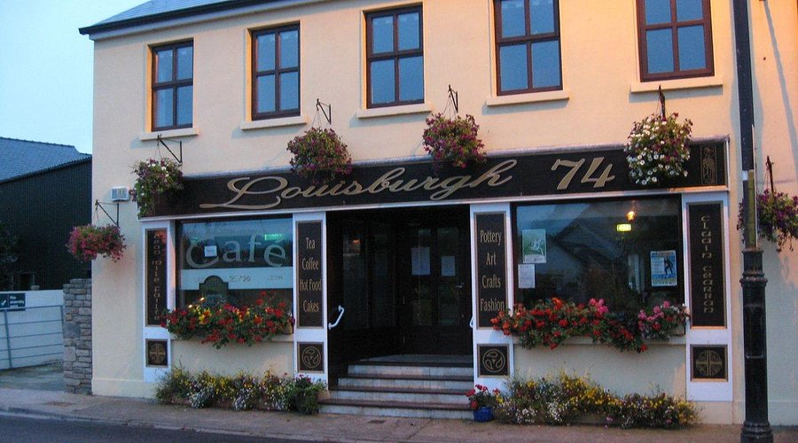 Quaint Irish café with floral displays, Louisburgh 74, offers tea, coffee, and crafts.